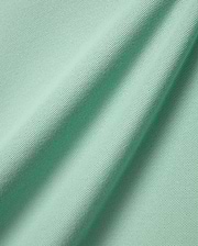 Mens Faye Pique Polo, a luxurious light mint green fabric swatch, showcasing the premium, finely textured pique weave with elegant, natural folds, reflecting refined streetwear quality.