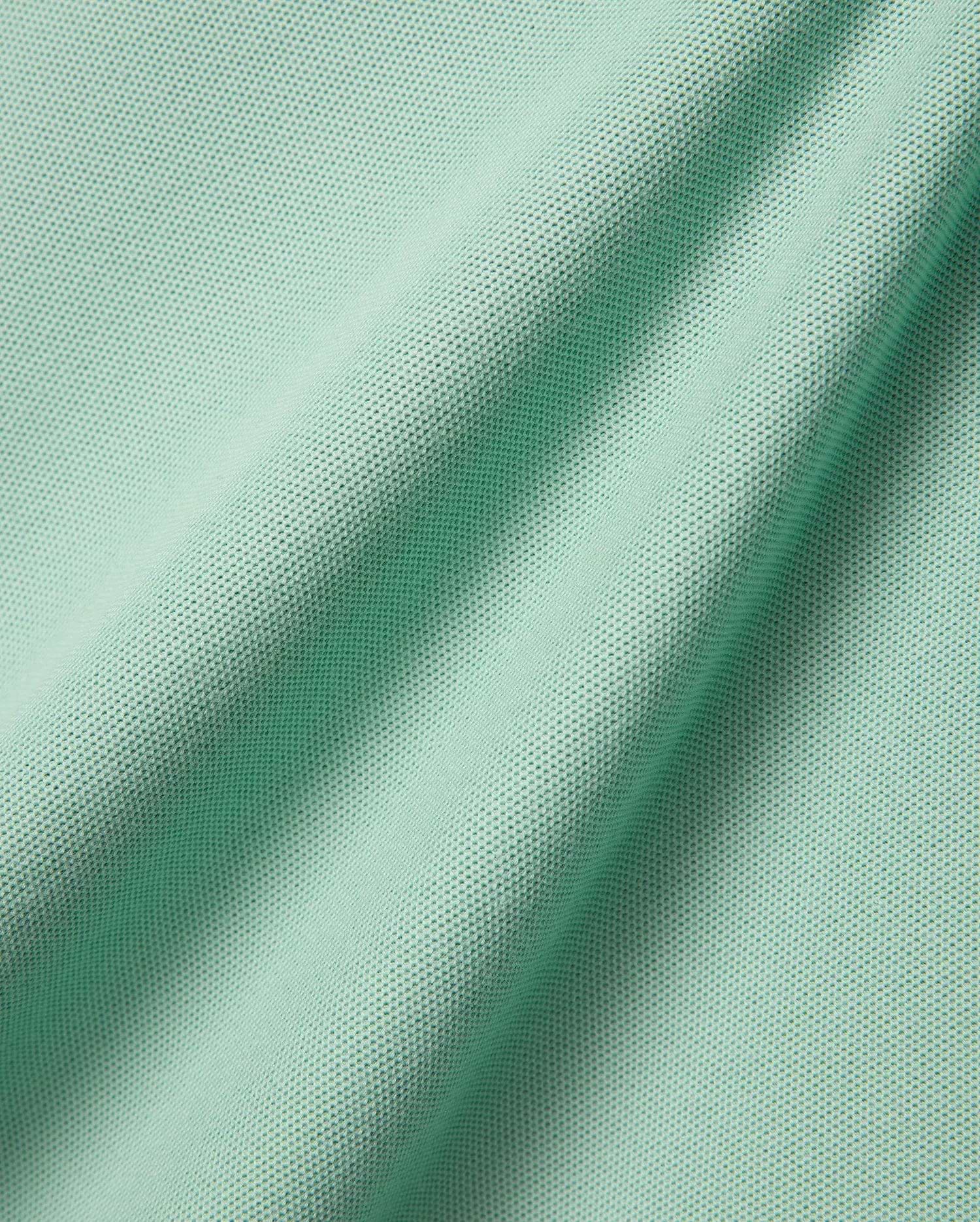 Mens Faye Pique Polo, a luxurious light mint green fabric swatch, showcasing the premium, finely textured pique weave with elegant, natural folds, reflecting refined streetwear quality.