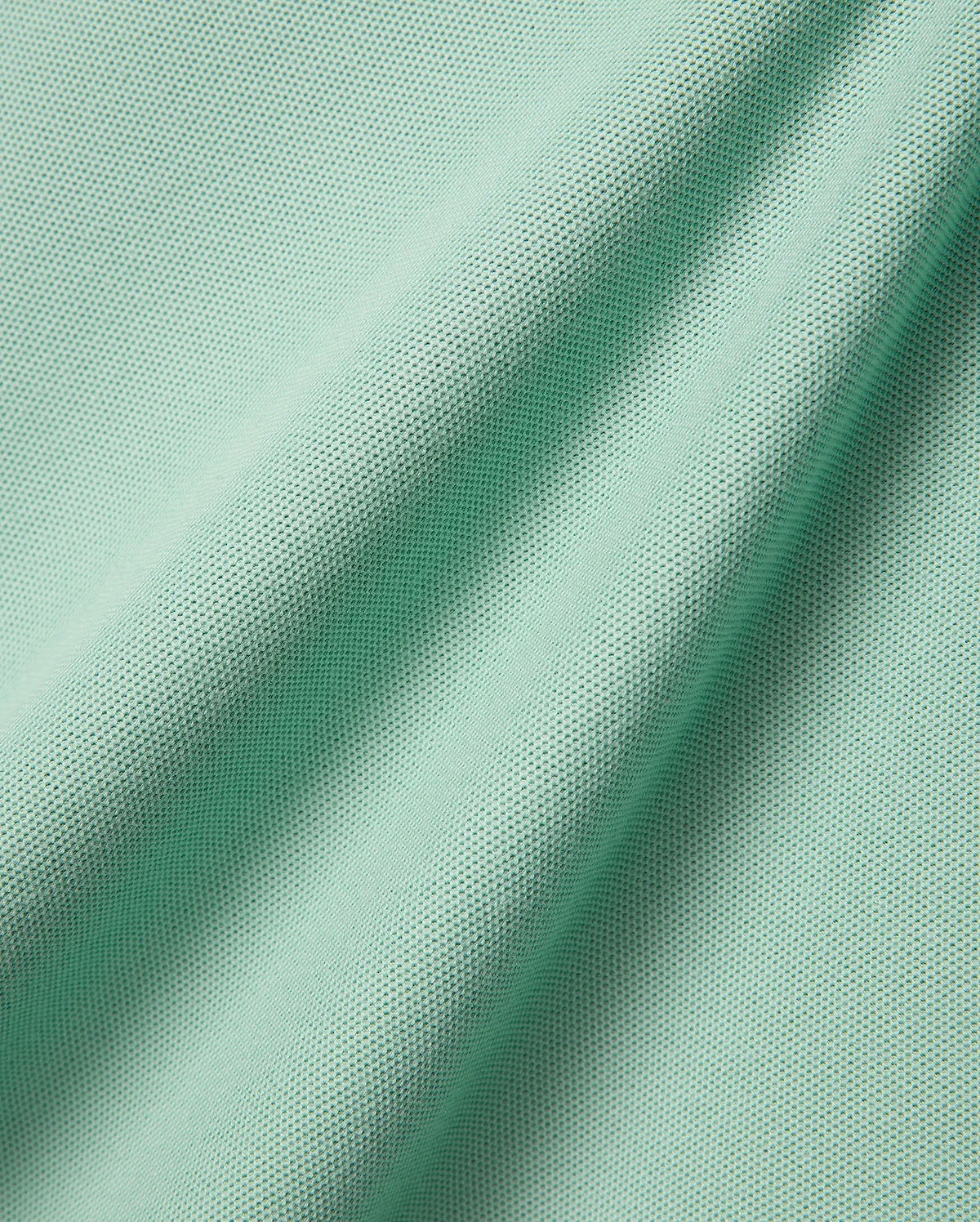 Mens Faye Pique Polo, a luxurious light mint green fabric swatch, showcasing the premium, finely textured pique weave with elegant, natural folds, reflecting refined streetwear quality.