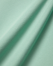 Mens Faye Pique Polo, a luxurious light mint green fabric swatch, showcasing the premium, finely textured pique weave with elegant, natural folds, reflecting refined streetwear quality.