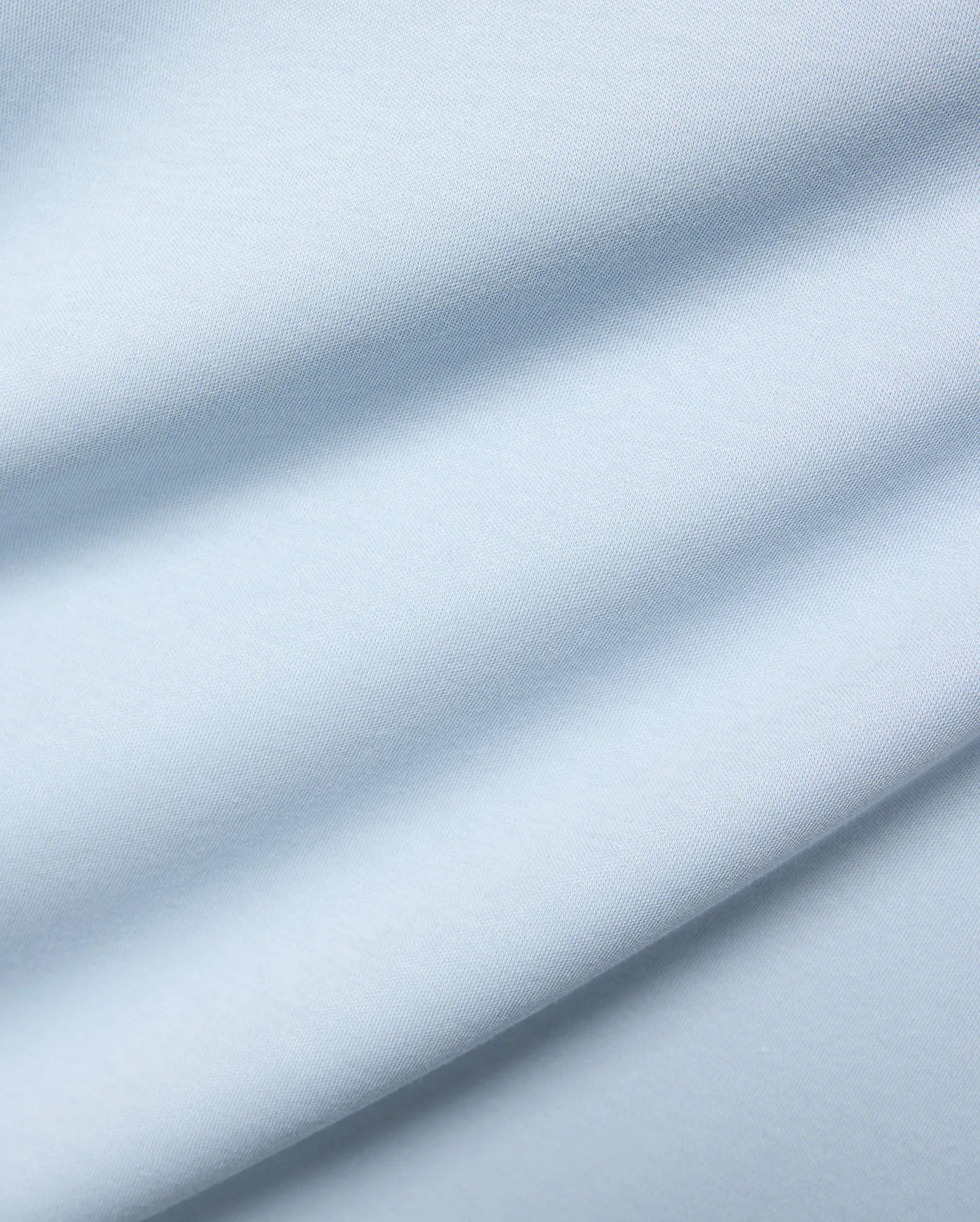 Mens Nasser Interlock Johnny Collar Polo, featuring a close-up of its soft, light blue interlock knit fabric with subtle texture and elegant draped folds. (6)