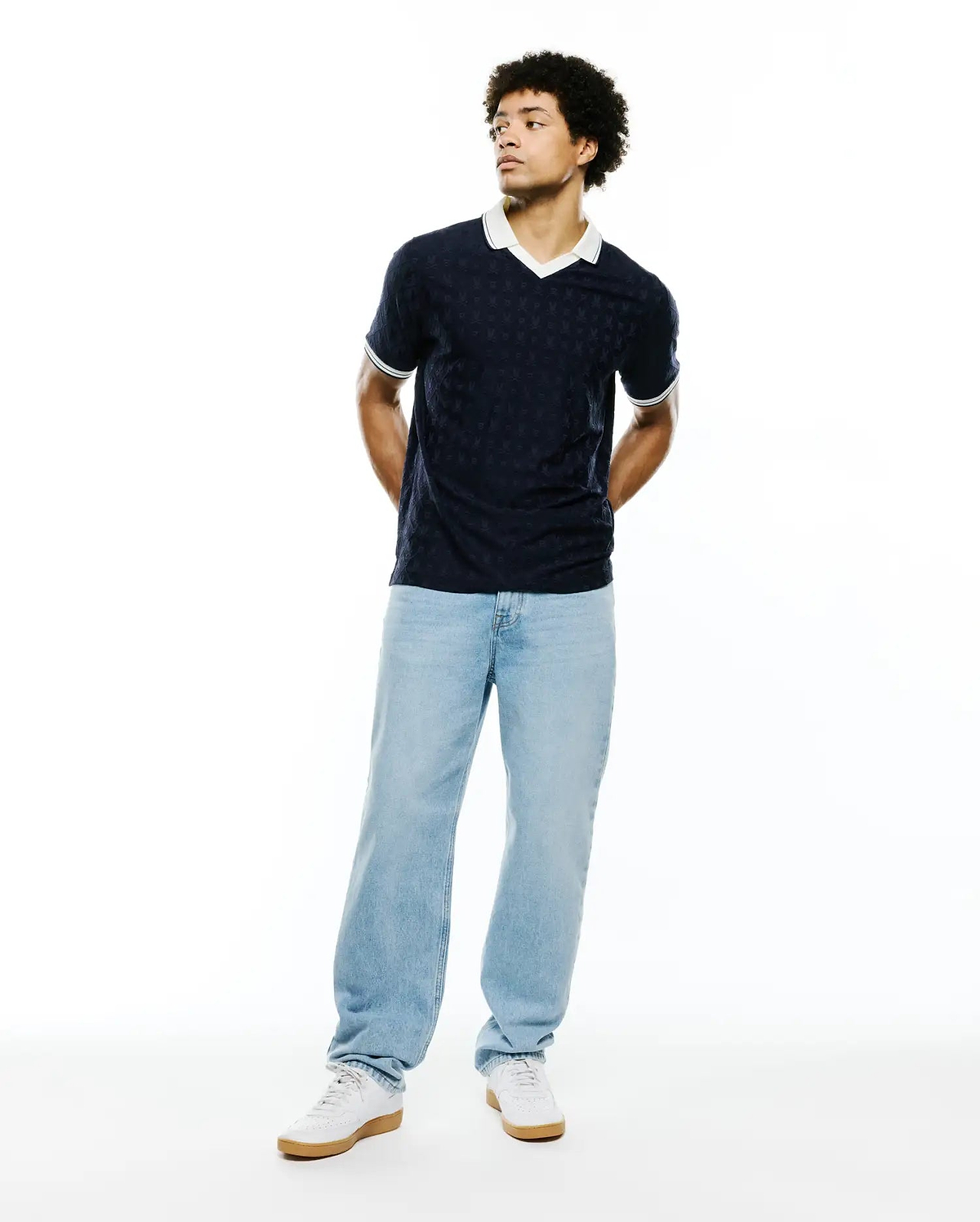 Mens Garry Jacquard Johnny Collar Polo in navy blue, featuring an all-over subtle bunny skull jacquard pattern, a crisp white Johnny collar, and ribbed cuffs with white and green tipping for a classic fit.