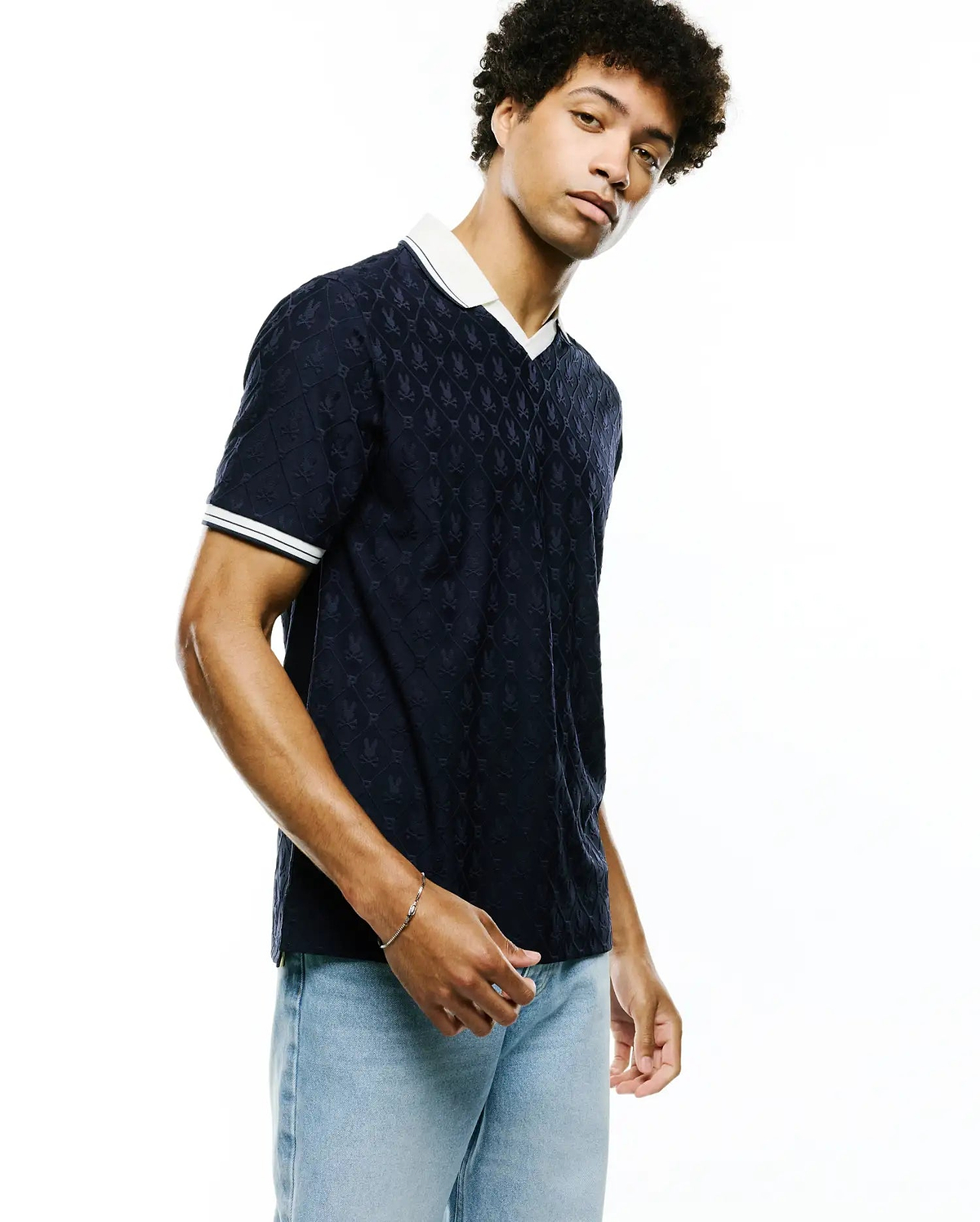 Mens Garry Jacquard Johnny Collar Polo in navy, featuring a white Johnny collar, white double-striped cuffs, and an all-over subtle Psycho Bunny skull jacquard pattern in a relaxed fit.