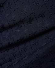 Mens Garry Jacquard Johnny Collar Polo in dark navy, featuring an all-over tone-on-tone jacquard knit pattern of the iconic Psycho Bunny skull logo within hexagonal shapes.