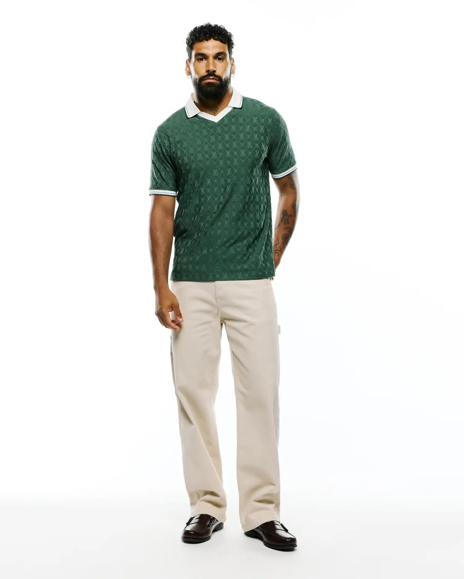 Mens Garry Jacquard Johnny Collar Polo in dark green, featuring an all-over bunny skull jacquard pattern, a white Johnny collar, and white striped cuffs, in a classic fit textured knit. (7)