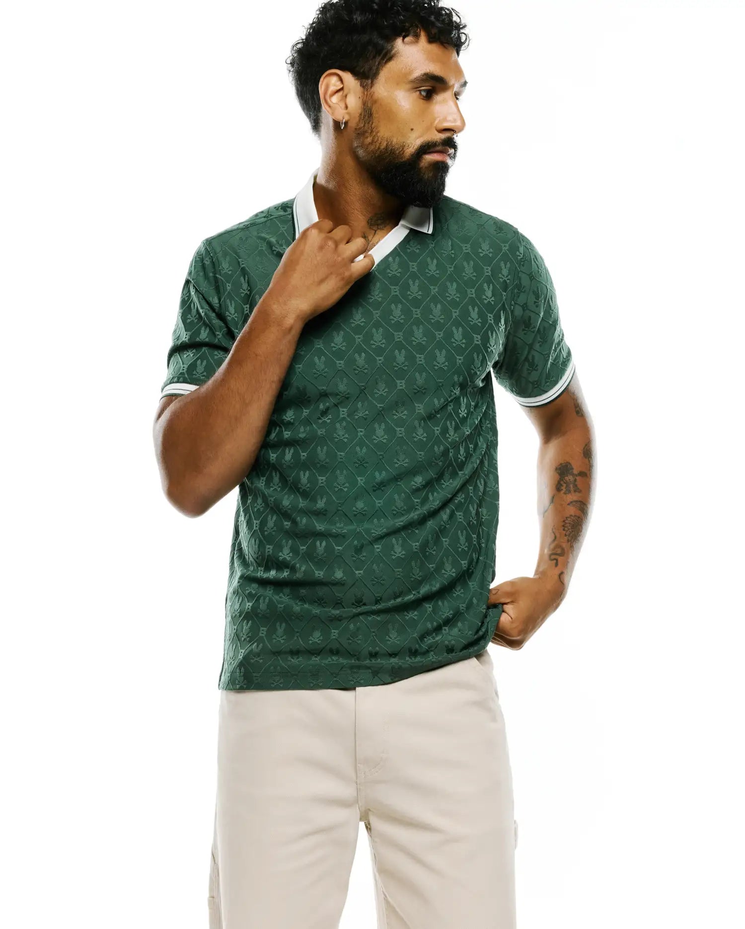 Mens Garry Jacquard Johnny Collar Polo in deep green, featuring an all-over tonal jacquard pattern of the iconic Psycho Bunny skull logo, a crisp white Johnny collar, and white striped sleeve cuffs, offering a refined slim fit. (6)