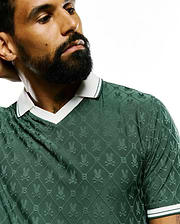 Mens Garry Jacquard Johnny Collar Polo in deep green, featuring an all-over textured Psycho Bunny skull logo pattern, with a white Johnny collar and ribbed cuffs accented by green stripes. (5)
