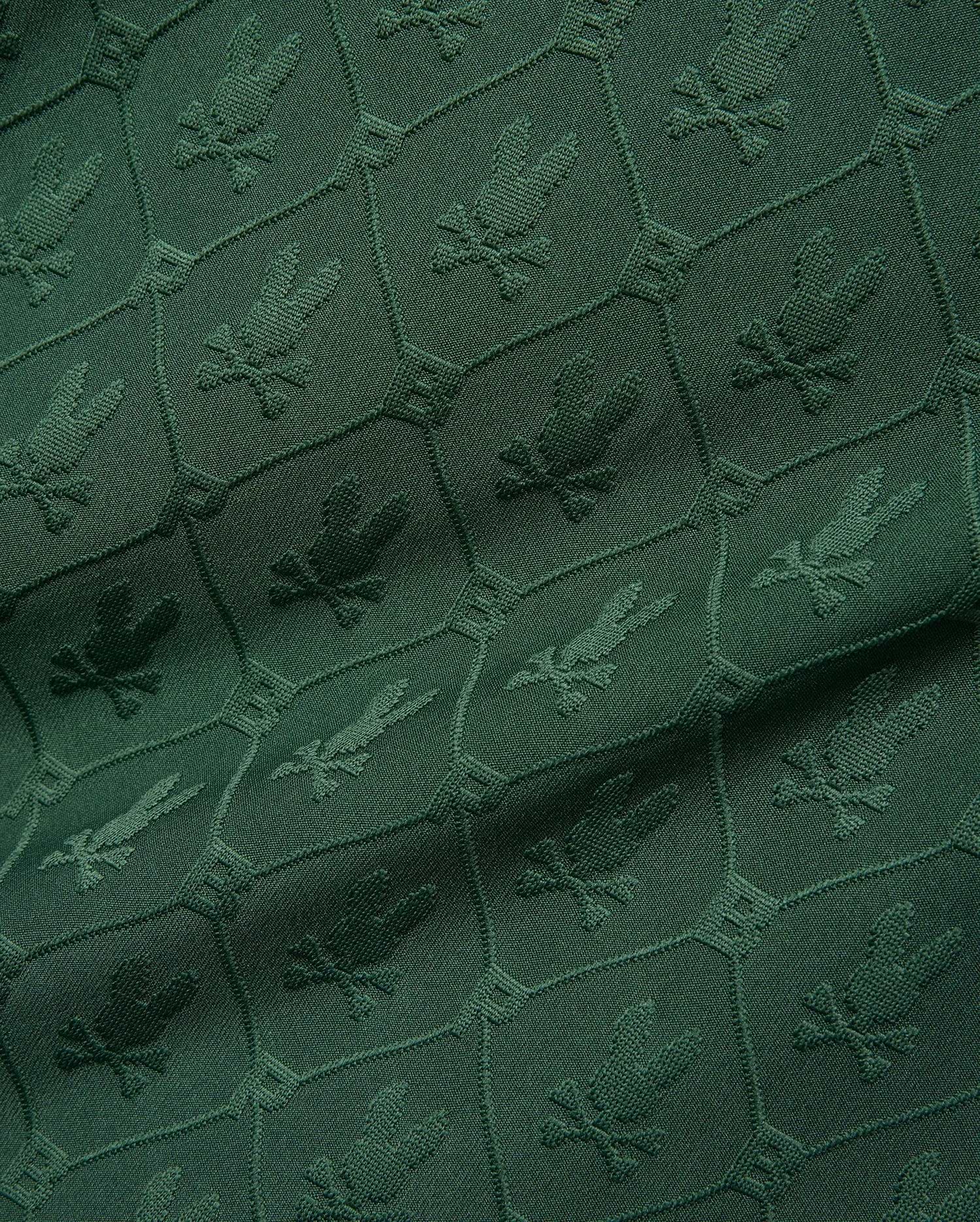 Mens Garry Jacquard Johnny Collar Polo in deep green, featuring an all-over tonal jacquard pattern of the iconic Psycho Bunny skull logo within a hexagonal grid. (9)