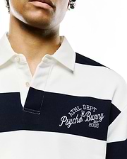 MENS KEVEN LS RELAXED FIT POLO, white and navy horizontal striped jersey knit, with a two-button placket and large white embroidered Psycho Bunny ATHL DEPT EST. 2005 logo on left chest.