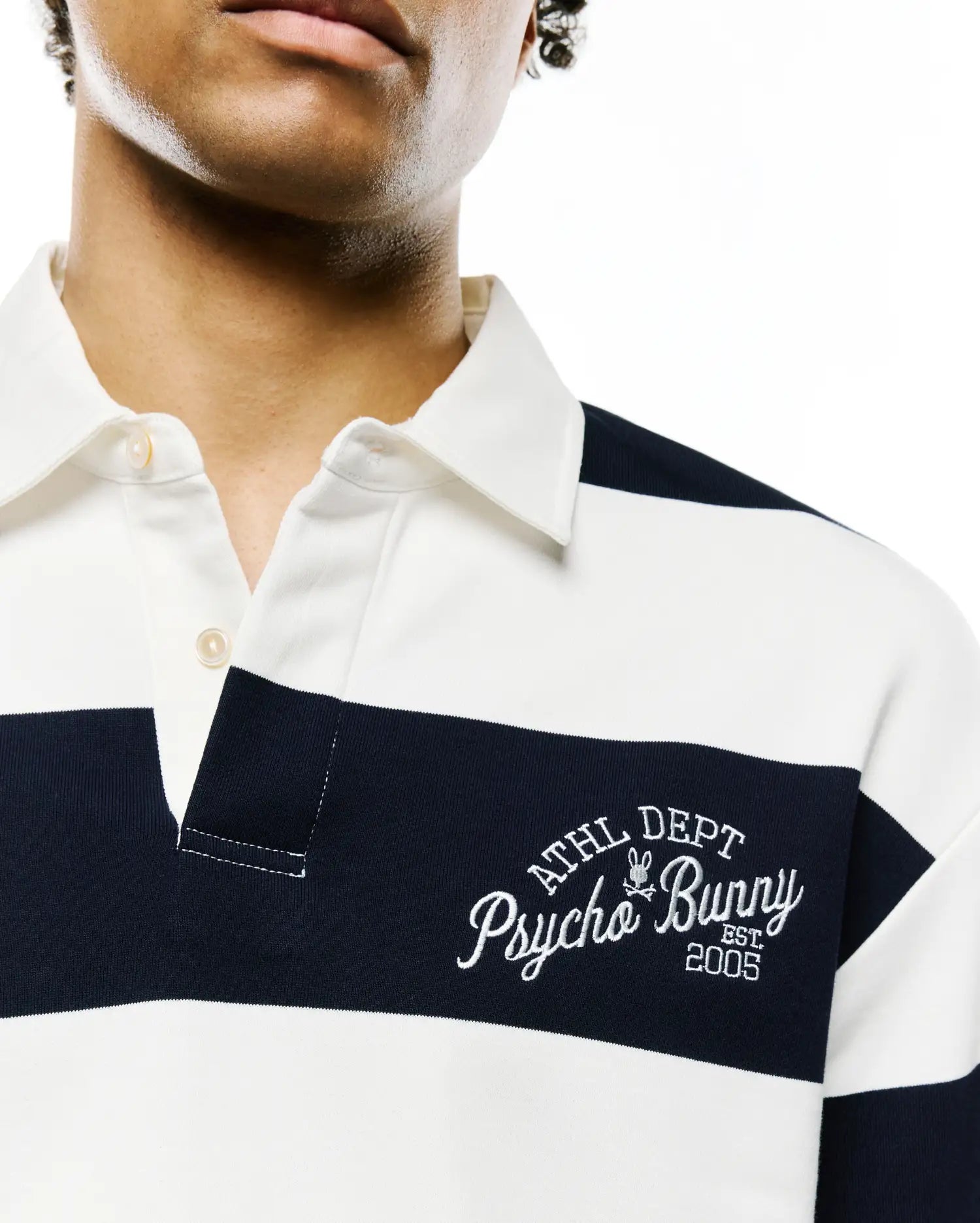 MENS KEVEN LS RELAXED FIT POLO, white and navy horizontal striped jersey knit, with a two-button placket and large white embroidered Psycho Bunny ATHL DEPT EST. 2005 logo on left chest.