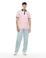 Mens Robin Pique Polo in classic fit pink pique fabric, featuring a navy blue collar, two-button placket, navy and white striped ribbed cuffs, and a small embroidered Psycho Bunny skull logo on the left chest.