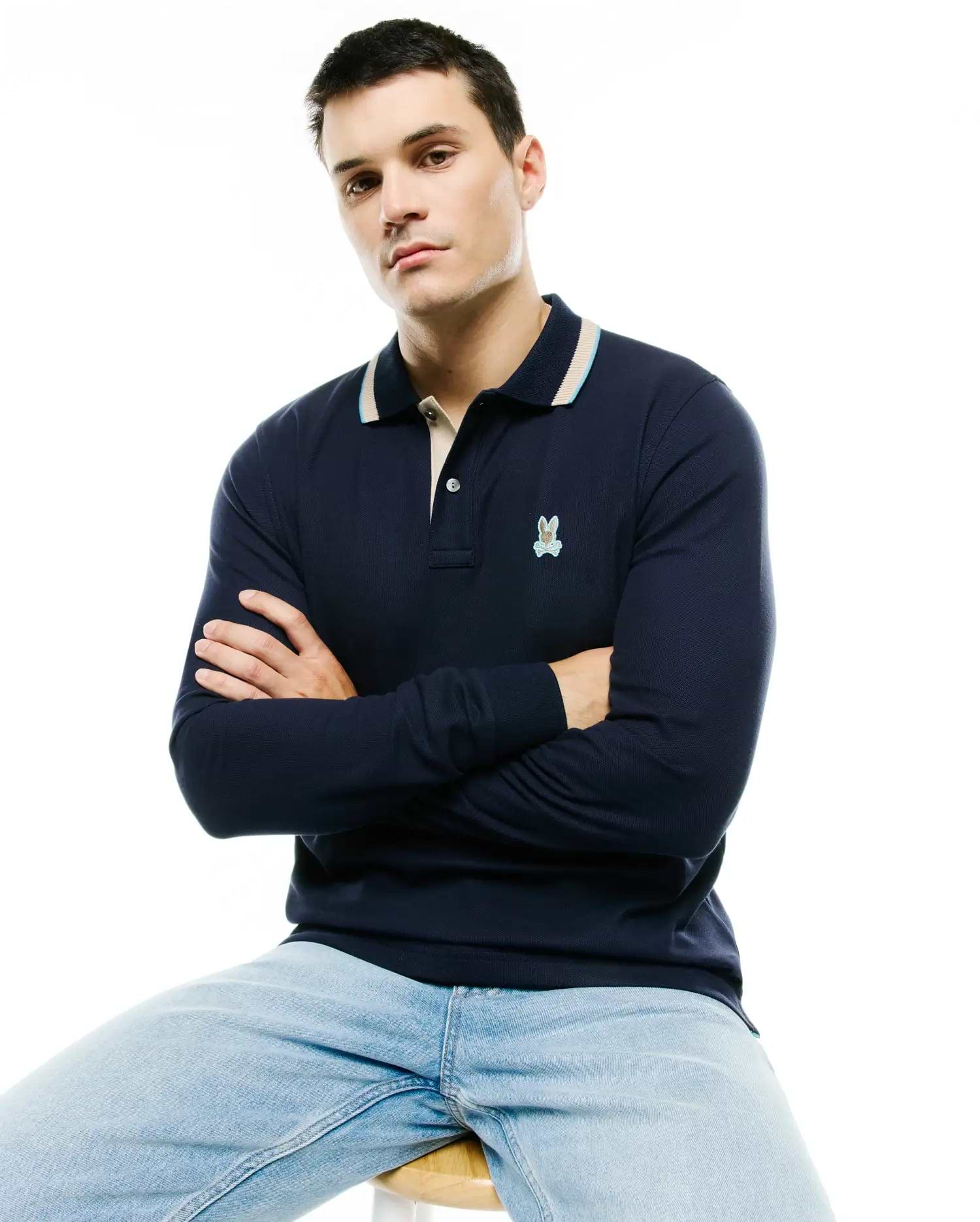 Men's Grover Pique Longsleeve Polo in navy, featuring a classic fit, pique texture, a beige and light blue striped collar, and a small embroidered Psycho Bunny skull logo on the left chest. (3)