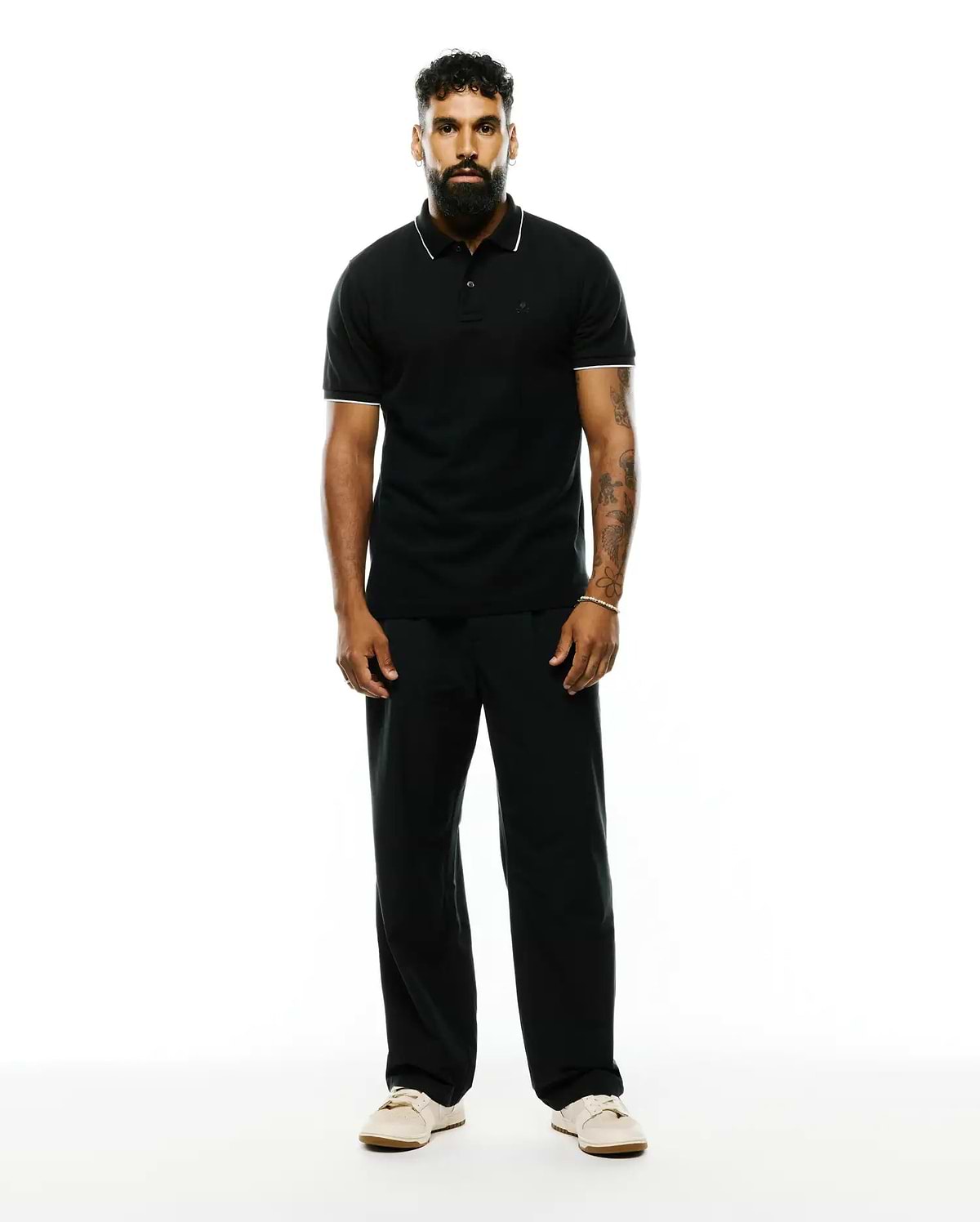 Premium Black Mens Ringston Pique Polo, classic fit, with white tipping on the collar and cuffs, featuring a small embroidered Psycho Bunny skull logo on the left chest.