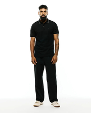 Premium Black Mens Ringston Pique Polo, classic fit, with white tipping on the collar and cuffs, featuring a small embroidered Psycho Bunny skull logo on the left chest.