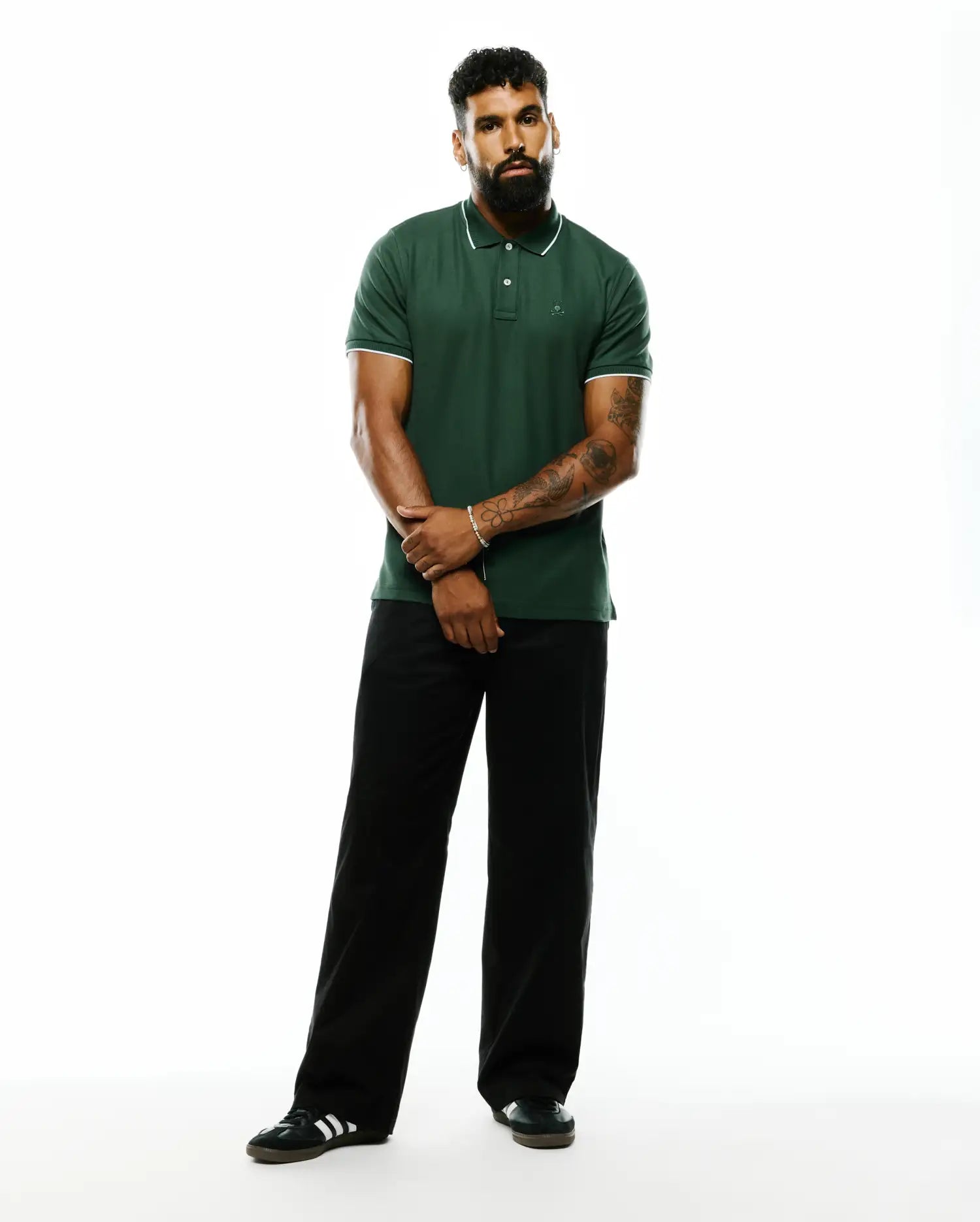 Mens Ringston Pique Polo, a classic fit dark green pique polo with white tipped collar and cuffs, featuring a small embroidered Psycho Bunny skull logo on the left chest.