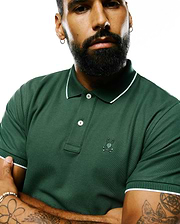 Mens Ringston Pique Polo in forest green pique knit, featuring a classic fit, white tipping on the ribbed collar and cuffs, two white buttons, and a small embroidered Psycho Bunny skull logo on the left chest.