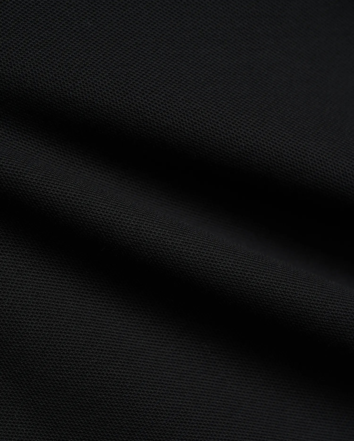 Psycho Bunny Mens Atley Pique Polo in deep black, showcasing the premium, breathable textured pique fabric with subtle folds, perfect for sophisticated streetwear. (6)