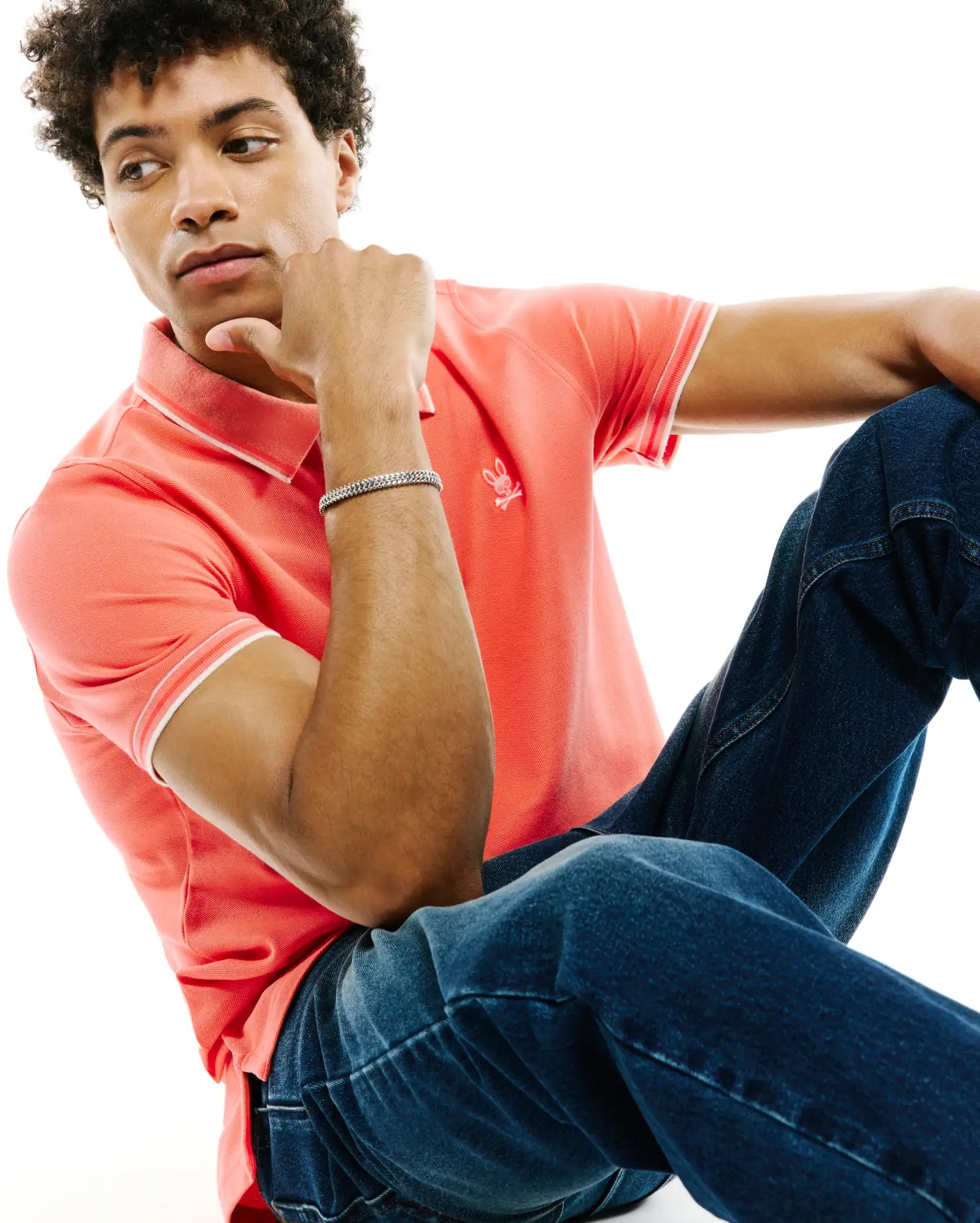 Mens Atley Pique Polo in coral, a classic fit pique knit with white tipped collar and cuffs, featuring a small embroidered Psycho Bunny skull logo on the left chest. (3)