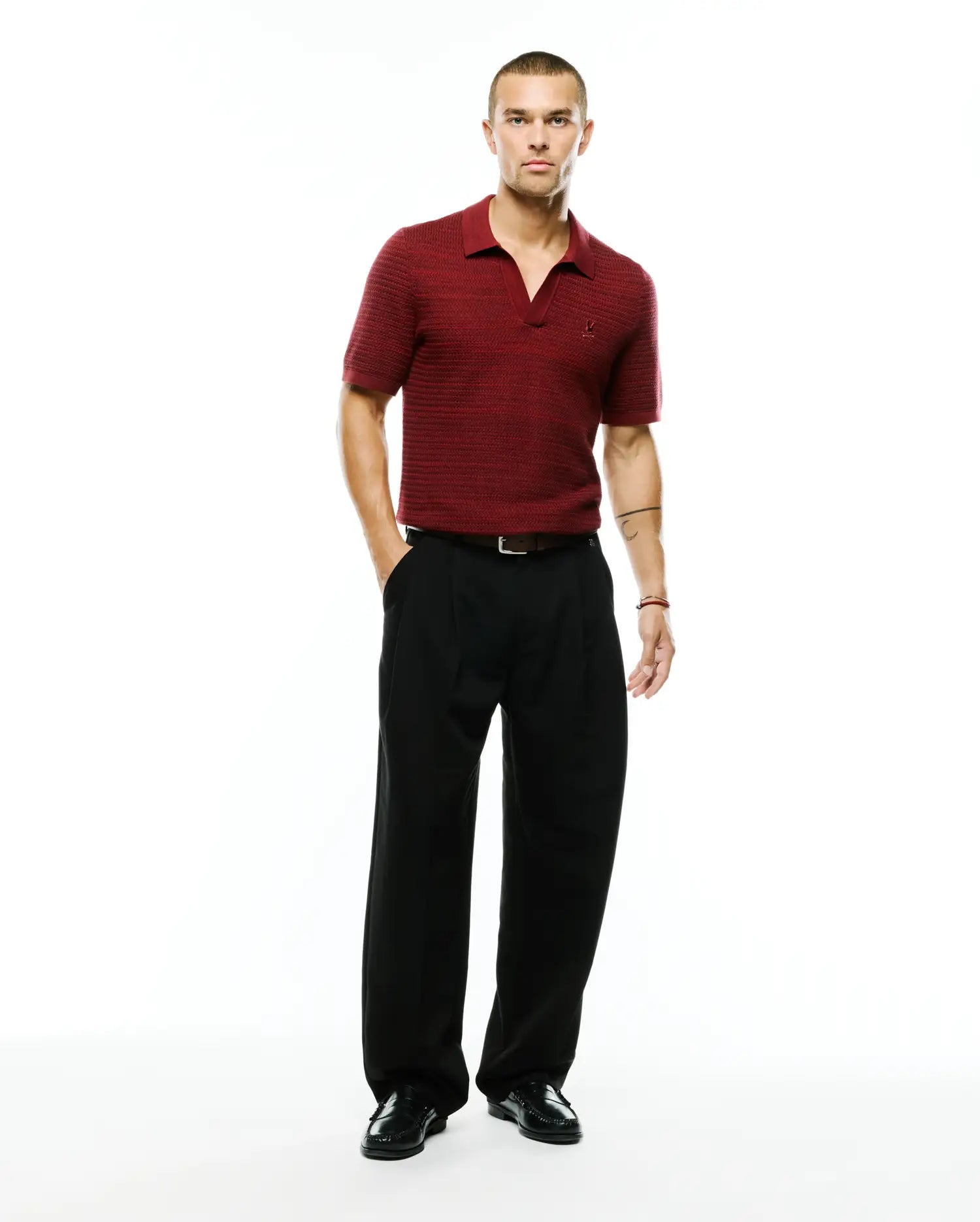 Men's Devon Braided Knit Polo in deep red, featuring a refined braided knit texture, open V-neck collar, and a small embroidered Psycho Bunny skull logo on the left chest. (4)