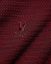 Men's Devon Braided Knit Polo in deep burgundy, featuring a rich braided knit texture and a small, tonal embroidered Psycho Bunny skull logo on the chest. (6)