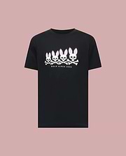 The Psycho Bunny MENS ARCHIVE GRADIANT BUNNY GRAPHIC TEE (MT0200029) showcases four iconic white and pink Bunny skull and crossbones with "BOLD SINCE 2005" text, set against a plain light pink background. (1)