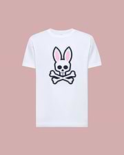 The Psycho Bunny MENS ARCHIVE BUNNY GRAPHIC TEE (MT0200031) is a white Pima cotton t-shirt featuring a large skull with bunny ears and crossbones graphic on the front, rib knit crewneck, shown against a muted pink background. (1)
