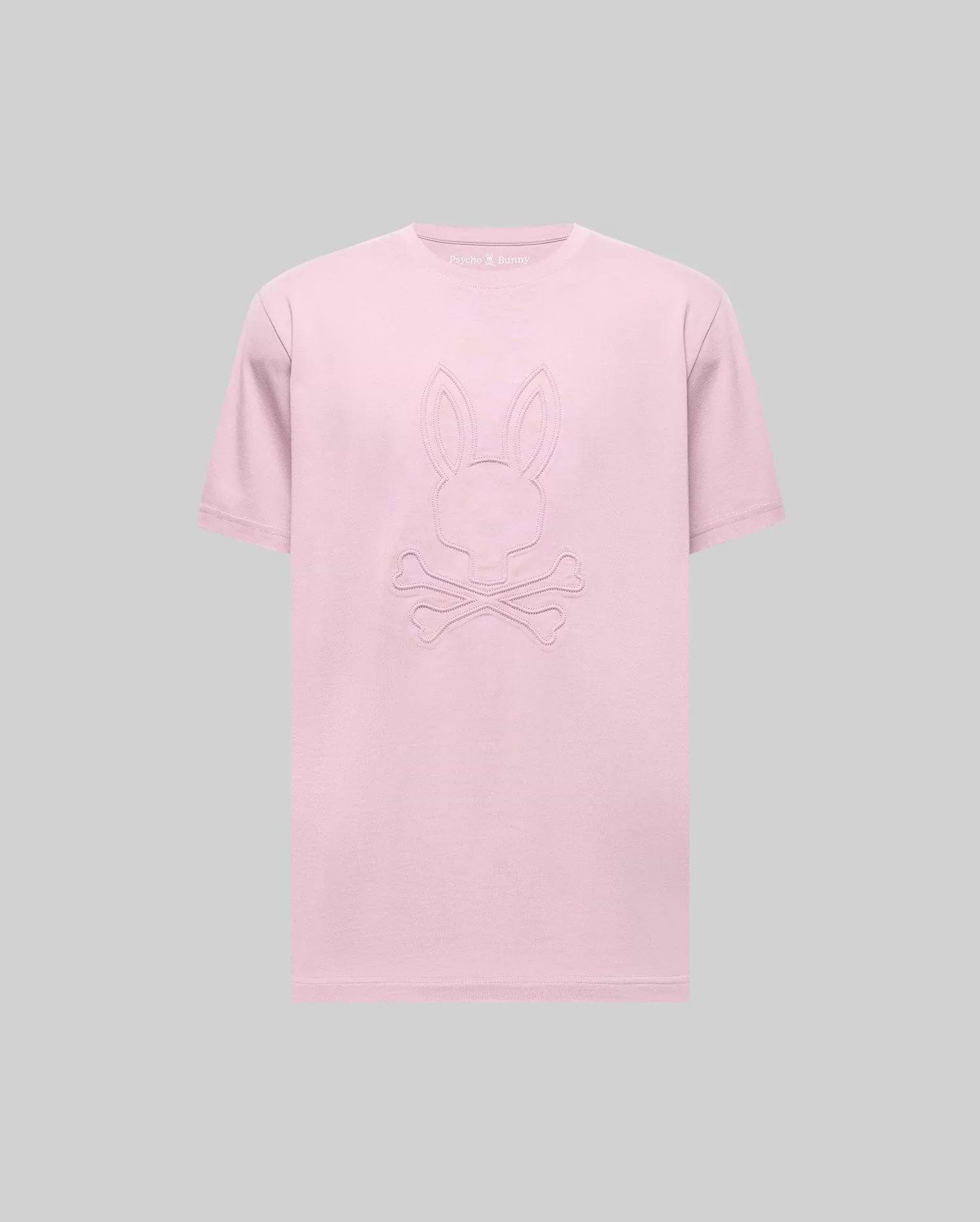 The Psycho Bunny MENS REMY GRAPHIC TEE (MT0200059) is a light pink Pima cotton short-sleeve tee with an embossed bunny logo above two crossed bones on the front, shown against a plain gray background. (1)