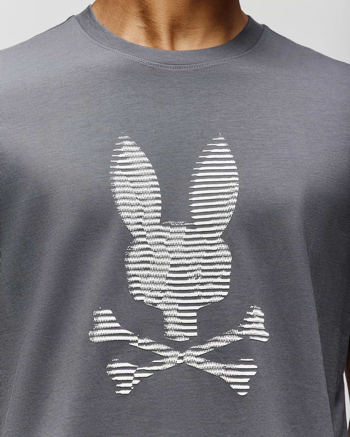 A close-up of the Psycho Bunny MENS GRANT BUNNY GRAPHIC TEE (MT0200081), crafted in Peru from soft Pima cotton, featuring a white bunny head with long ears above crossed bones for a playful twist on the classic graphic. (3)
