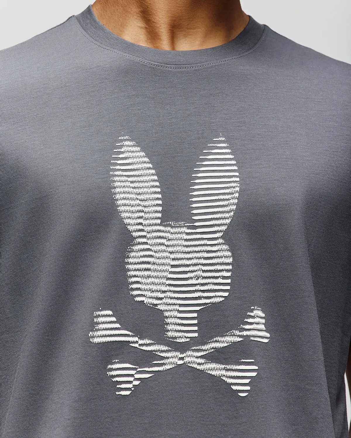A close-up of the Psycho Bunny MENS GRANT BUNNY GRAPHIC TEE (MT0200081), crafted in Peru from soft Pima cotton, featuring a white bunny head with long ears above crossed bones for a playful twist on the classic graphic. (3)