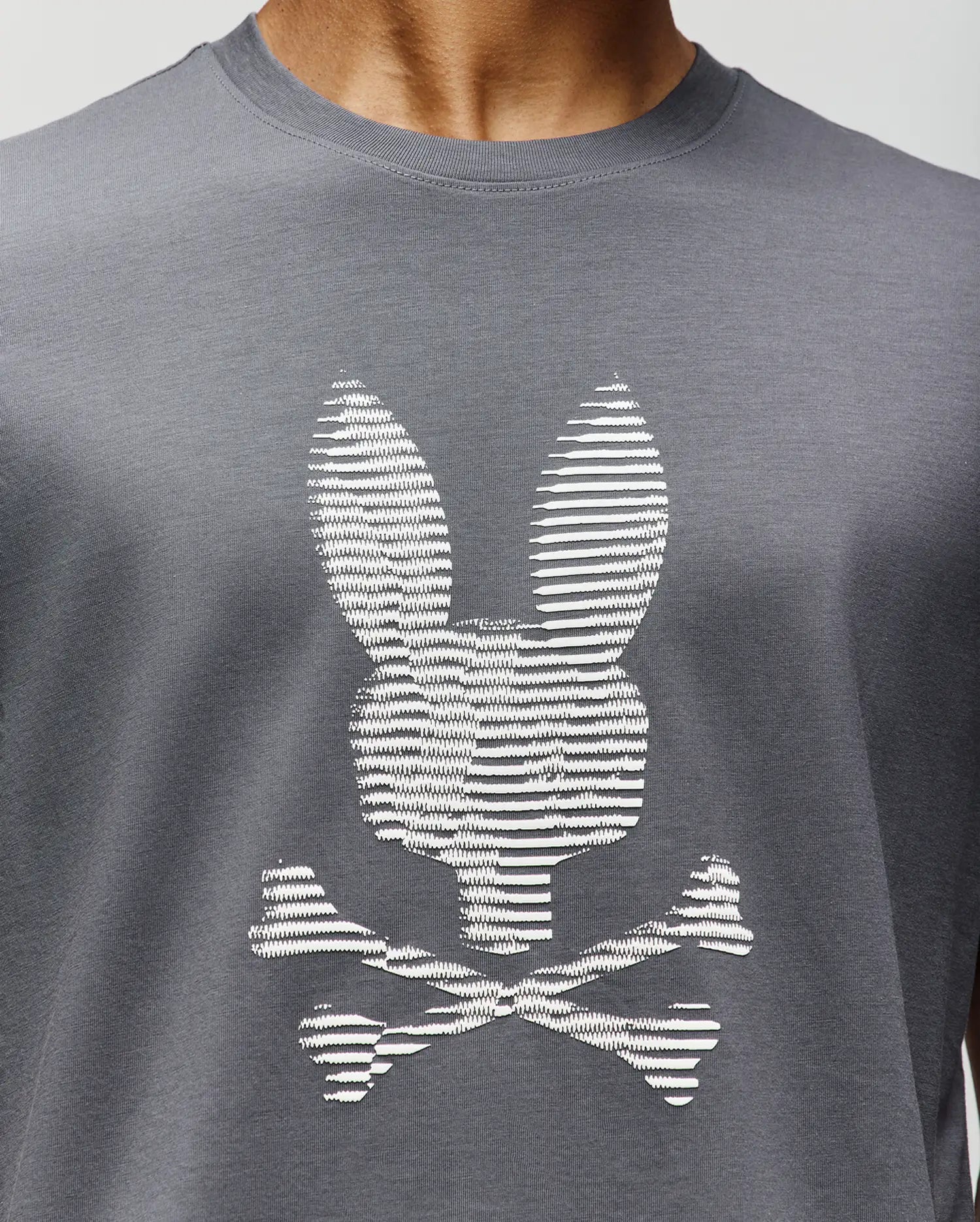 A close-up of the Psycho Bunny MENS GRANT BUNNY GRAPHIC TEE (MT0200081), crafted in Peru from soft Pima cotton, featuring a white bunny head with long ears above crossed bones for a playful twist on the classic graphic. (3)