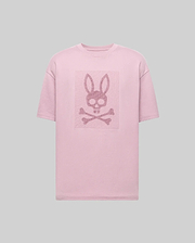 The Psycho Bunny MENS REECE OVERSIZED TEE (MT0200082) is a light pink, heavyweight jersey tee in a relaxed fit, featuring a centered skull with bunny ears above crossed bones on the chest against a plain gray background. (5)