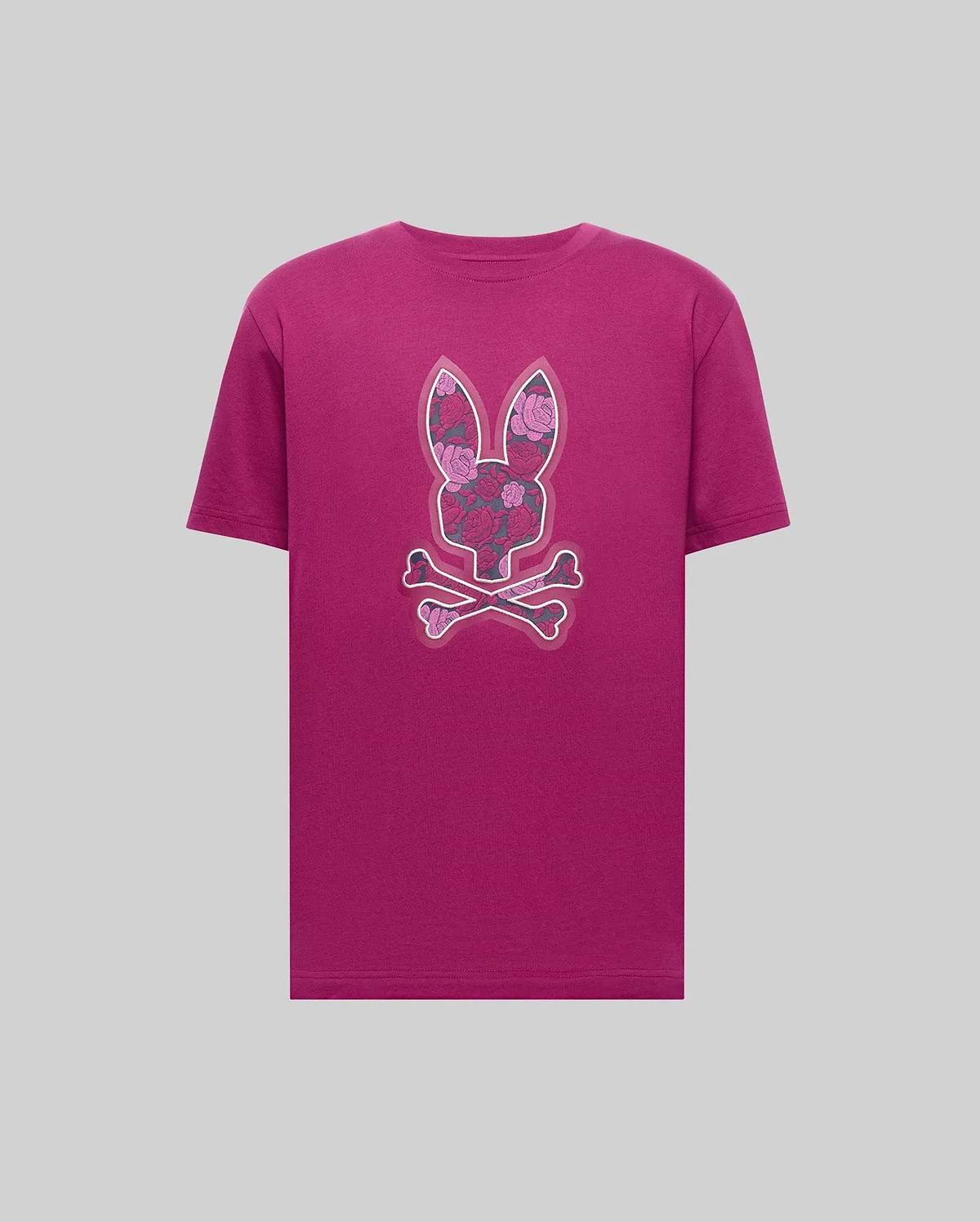The Psycho Bunny MENS ROWEN BUNNY GRAPHIC TEE (MT0200101) is a magenta Pima cotton tee featuring a bold floral-patterned bunny head above crossed bones, displayed on a simple gray backdrop. (1)