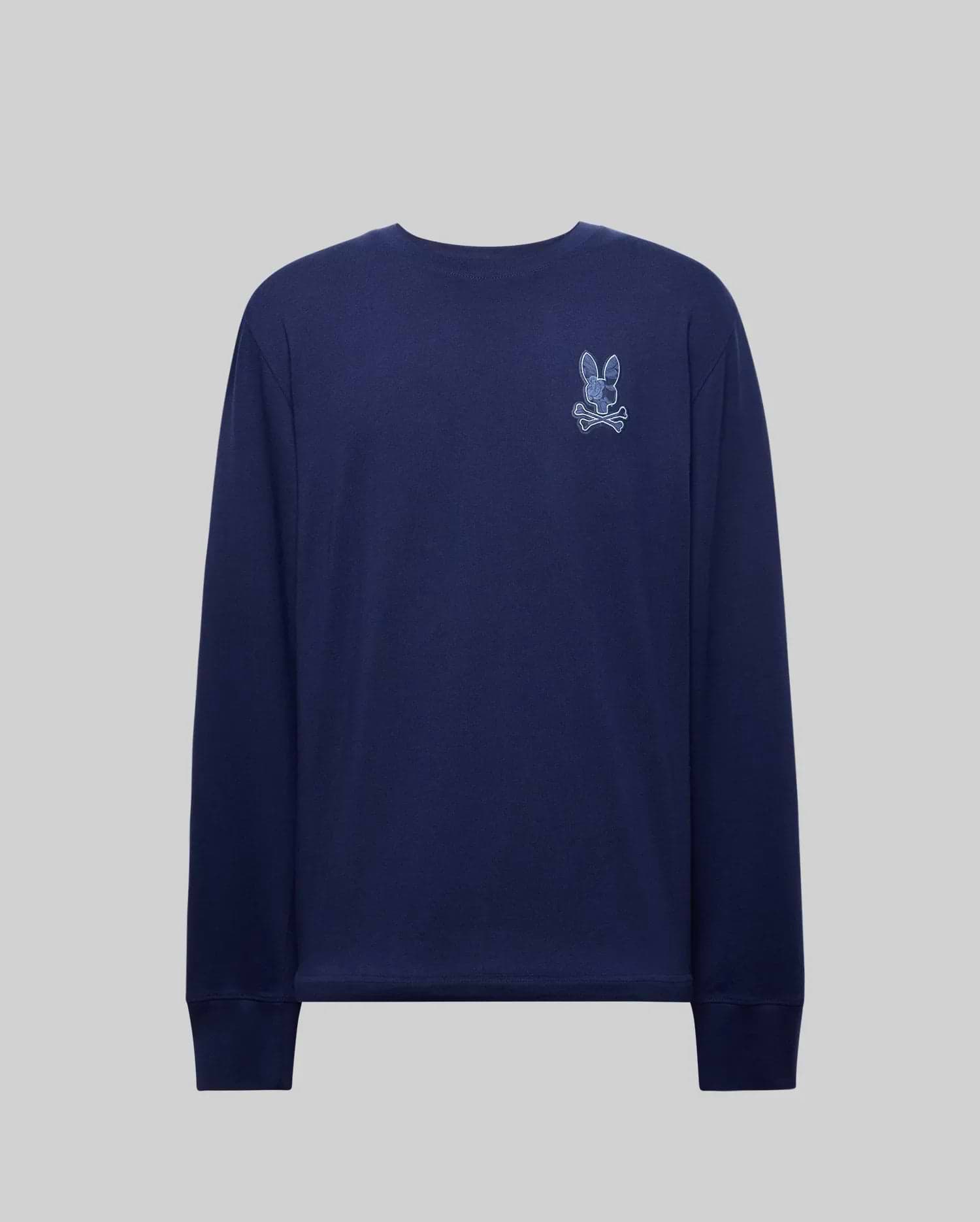 The Psycho Bunny MENS ROWEN GRAPHIC TEE (MT0200103) is a navy Pima cotton long sleeve shirt with a small embroidered rabbit and crossbones patch on the upper left chest, shown on a plain gray background.