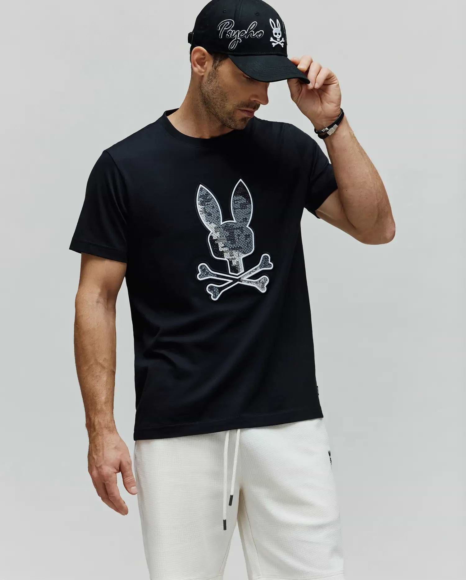 Mens Olivier Graphic Tee, a black premium jersey t-shirt with a classic fit, featuring a large, iconic white-outlined, textured grey Psycho Bunny skull and crossbones graphic on the chest. (4)