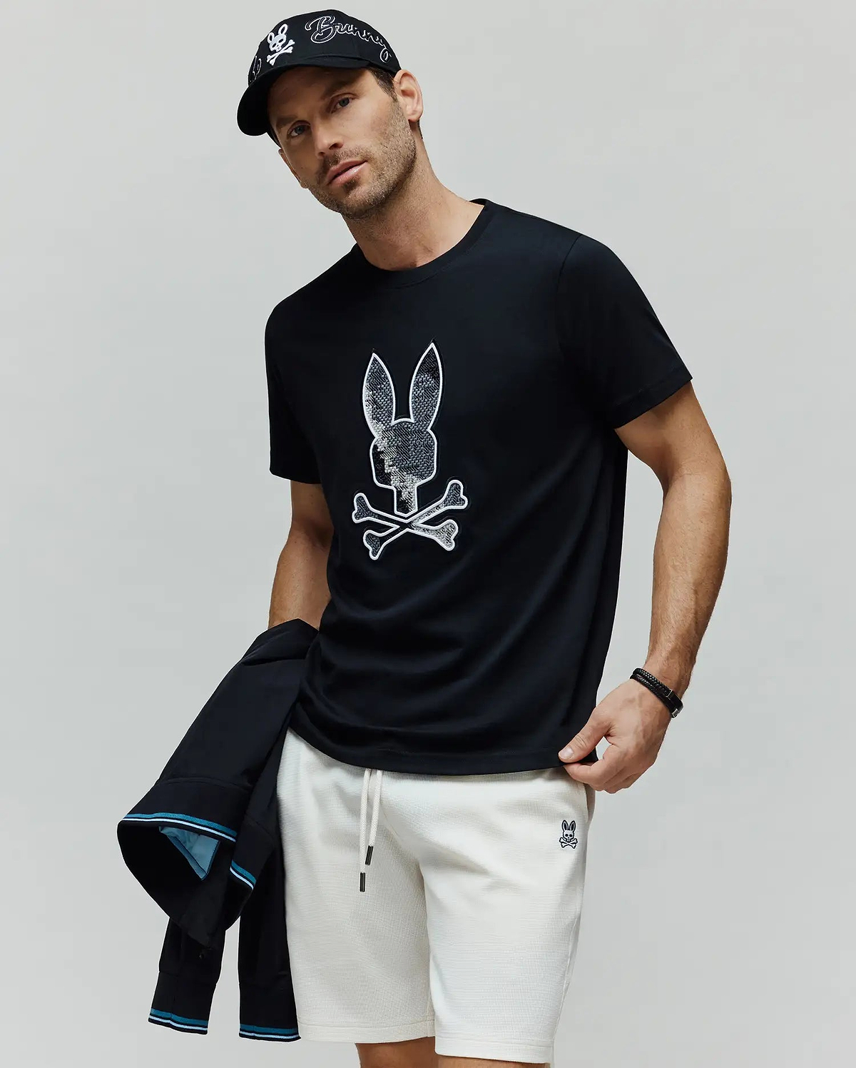 Mens Olivier Graphic Tee, a classic fit black jersey t-shirt featuring a large, textured white Psycho Bunny skull and crossbones graphic prominently on the chest. (2)