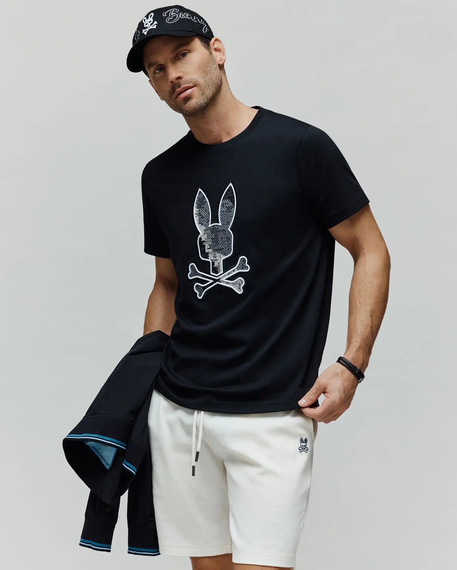 Mens Olivier Graphic Tee, a classic fit black jersey t-shirt featuring a large, textured white Psycho Bunny skull and crossbones graphic prominently on the chest. (2)