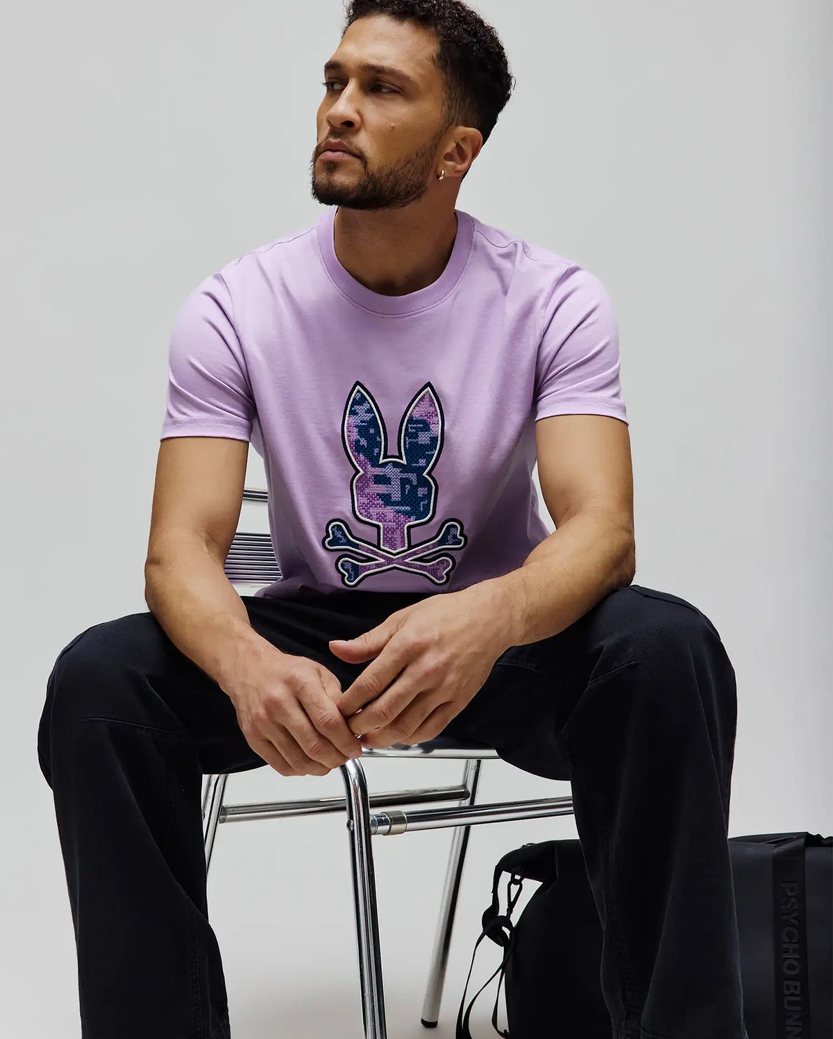 Mens Olivier Graphic Tee, a classic fit lavender jersey t-shirt featuring a large, pixelated purple and blue digital camo Psycho Bunny skull and crossbones logo centered on the chest. (4)