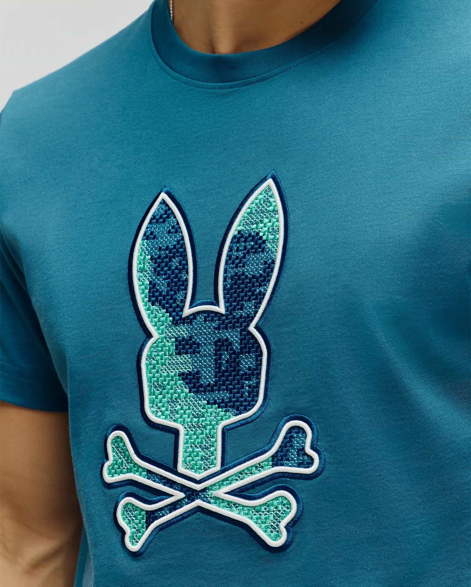 Mens Olivier Graphic Tee in teal, featuring a large central embroidered pixelated green and dark blue bunny skull logo with white outline on soft jersey knit fabric, classic fit. (3)
