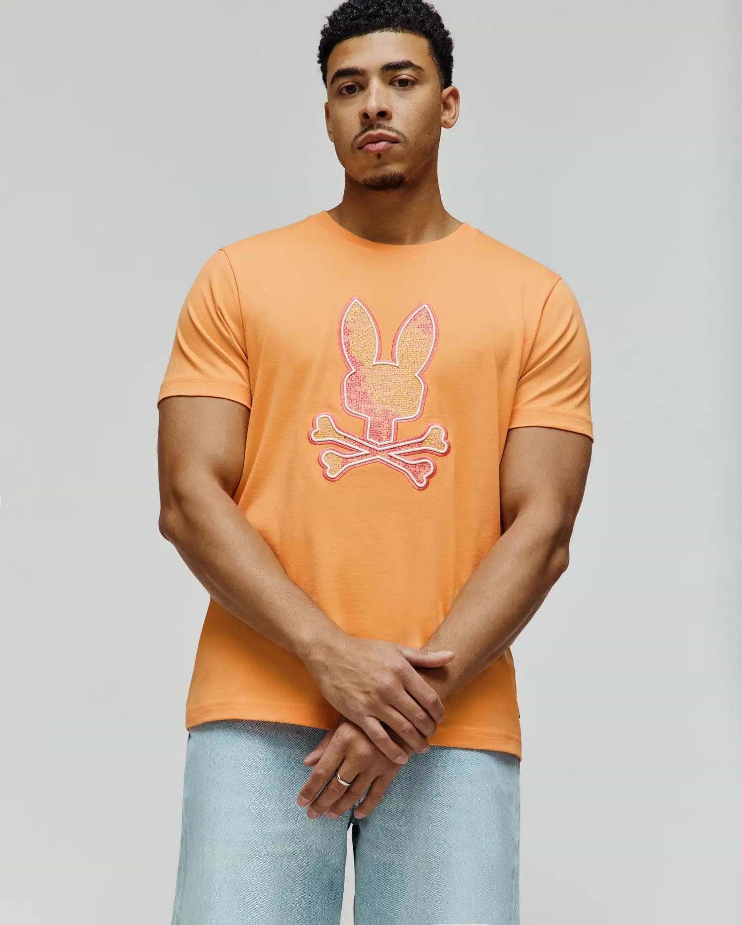 Vibrant Orange Mens Olivier Graphic Tee, classic fit, smooth jersey knit, featuring a large, textured pink, yellow, and white Psycho Bunny skull and crossbones graphic on the chest. (4)