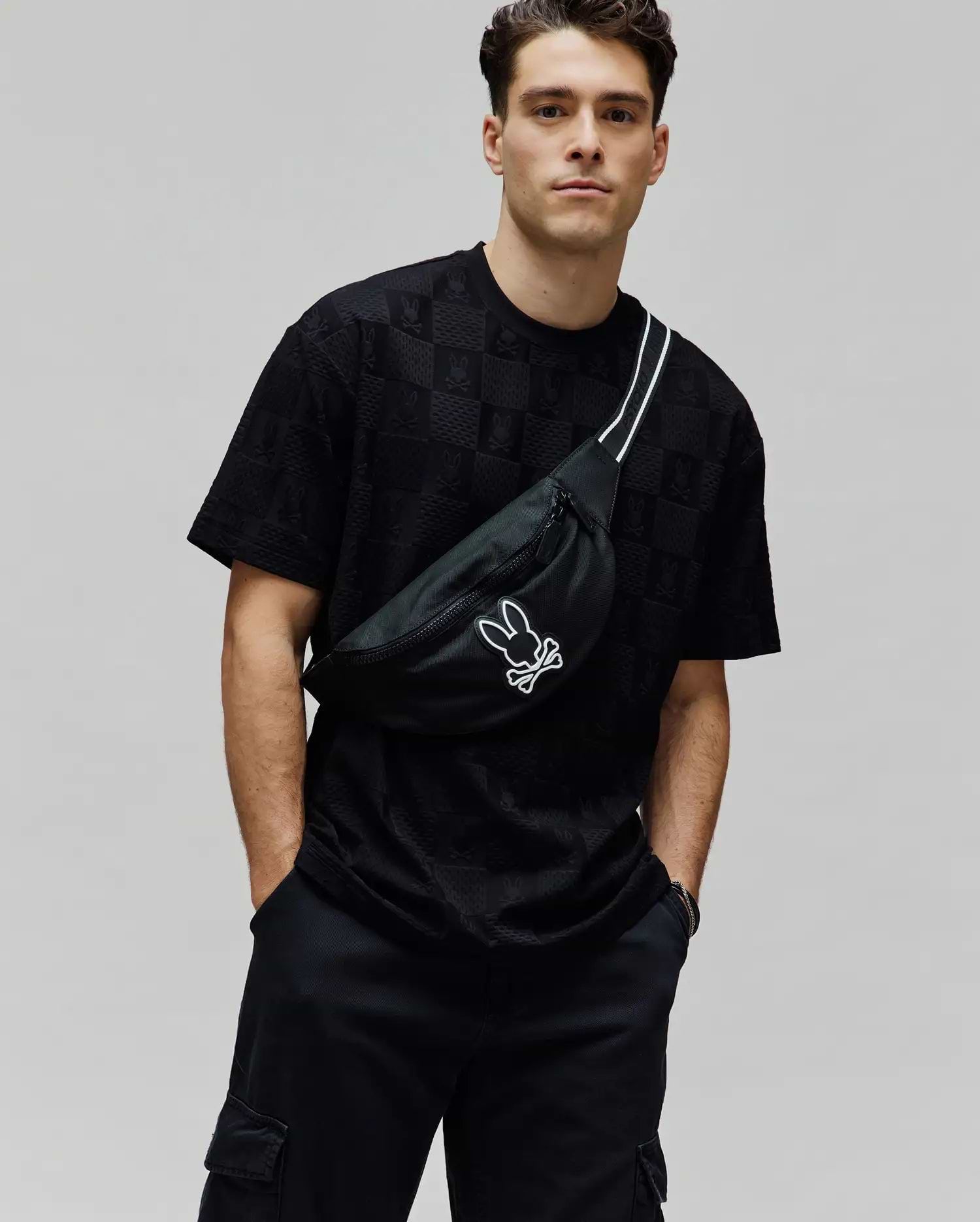 Mens Dustin Oversized Tee, a black oversized jersey t-shirt with a subtle all-over embossed Psycho Bunny skull pattern, embodying refined streetwear. (1)