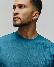 Mens Dustin Oversized Tee in teal, featuring an all-over jacquard checkerboard pattern with embossed Psycho Bunny skull logos and varied textured squares, in a soft knit. (3)