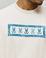 Mens Olivier Oversized Tee in cream, featuring a large central chest embroidery with five alternating blue Psycho Bunny skull logos framed by a woven-look blue border on soft jersey fabric. (2)