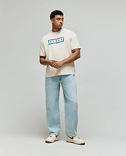 Mens Olivier Oversized Tee in cream jersey knit, featuring a prominent central chest graphic with a vibrant blue bandana-style pattern and white Psycho Bunny skull logos. (3)
