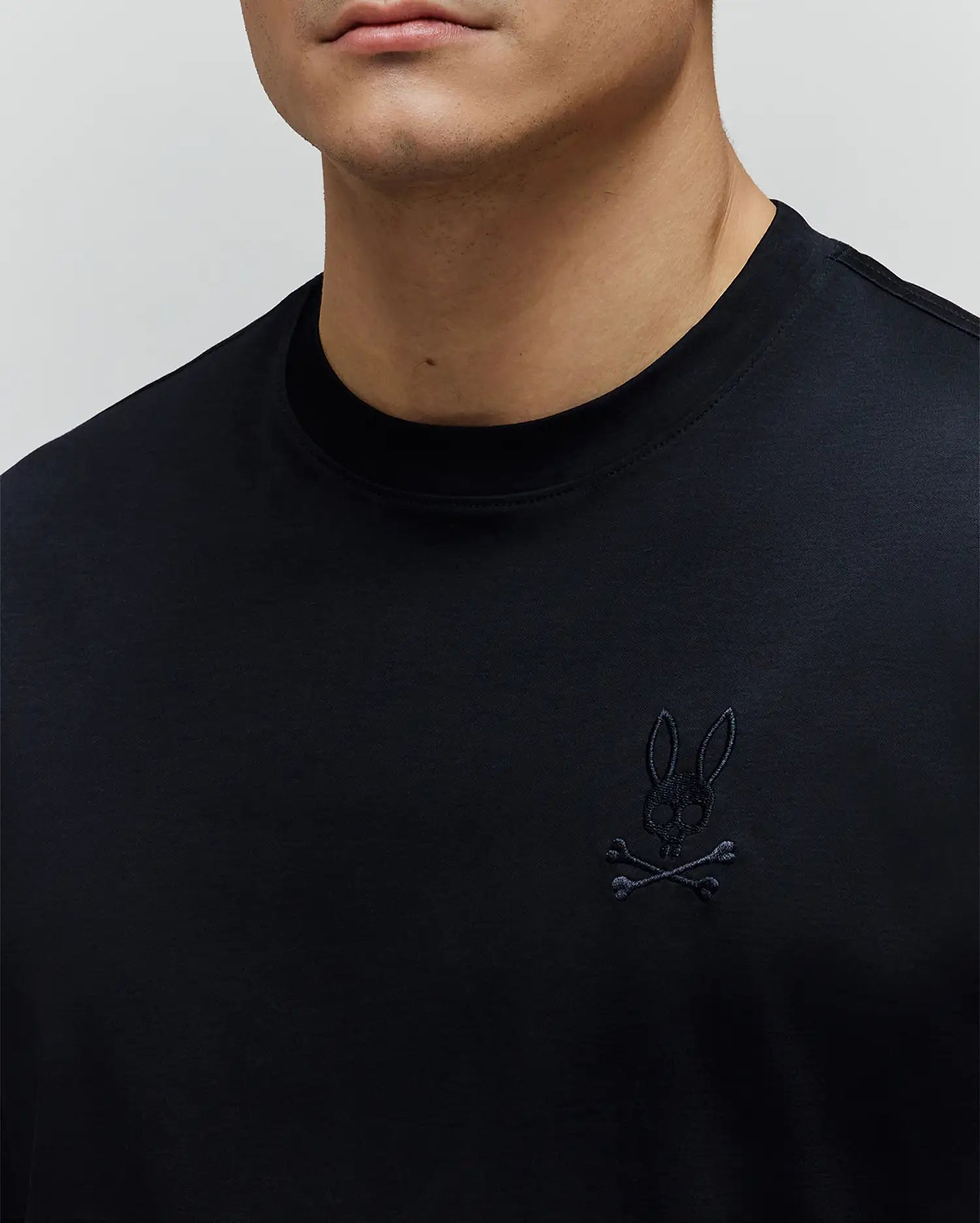 Mens Oscar Oversized Tee in black, crafted from smooth jersey fabric with an oversized fit. Features a small, tonal black embroidered Psycho Bunny skull logo on the left chest.