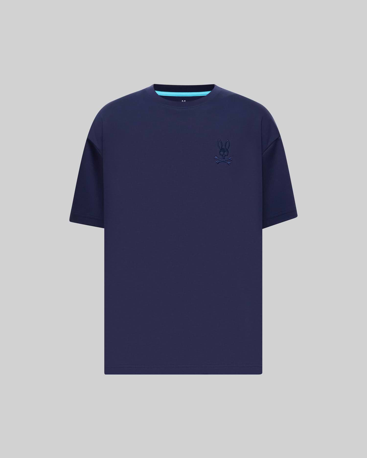 Mens Oscar Oversized Tee in navy blue jersey knit, featuring a relaxed fit, small embroidered Psycho Bunny skull logo on the left chest, and a light blue accent stripe on the inner collar.