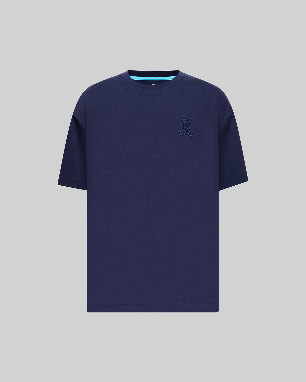 Mens Oscar Oversized Tee in navy blue jersey knit, featuring a relaxed fit, small embroidered Psycho Bunny skull logo on the left chest, and a light blue accent stripe on the inner collar.