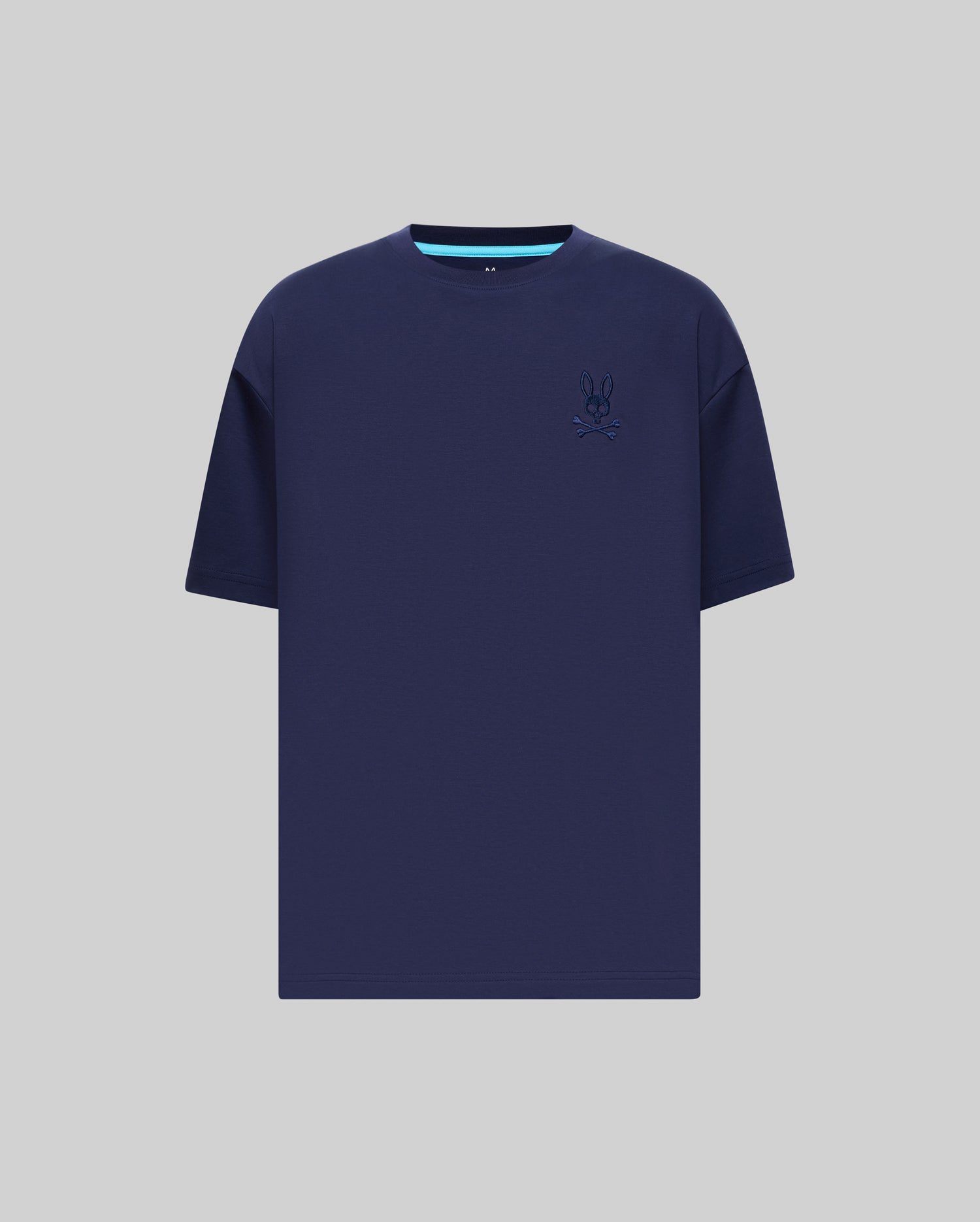 Mens Oscar Oversized Tee in navy blue jersey knit, featuring a relaxed fit, small embroidered Psycho Bunny skull logo on the left chest, and a light blue accent stripe on the inner collar.