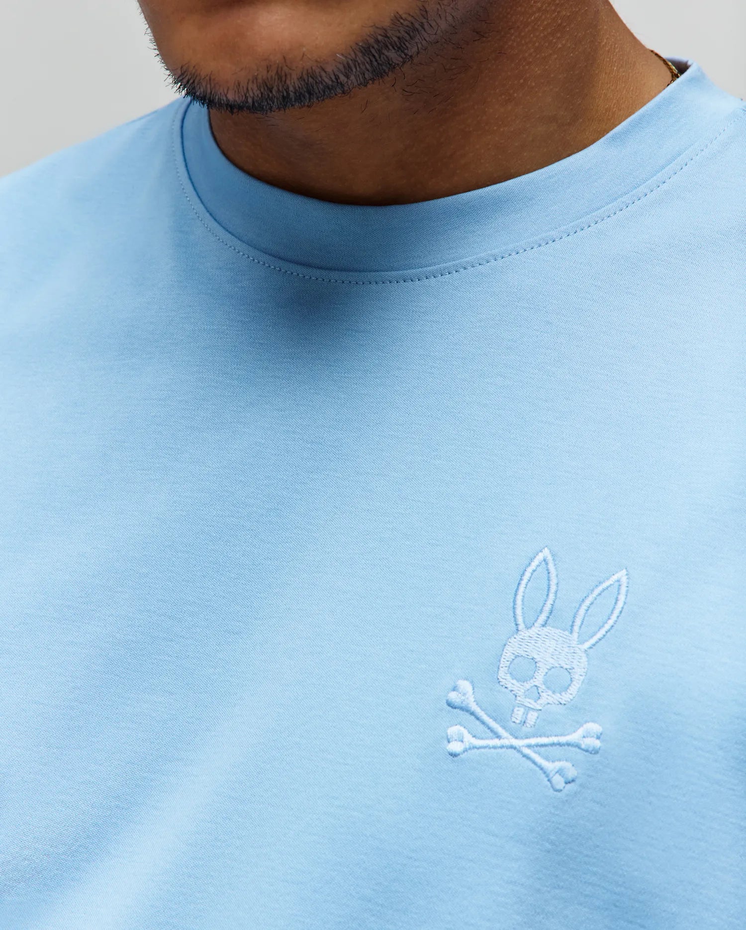 Mens Oscar Oversized Tee in light blue, soft jersey knit, with a small white embroidered iconic Psycho Bunny skull and crossbones logo on the left chest.