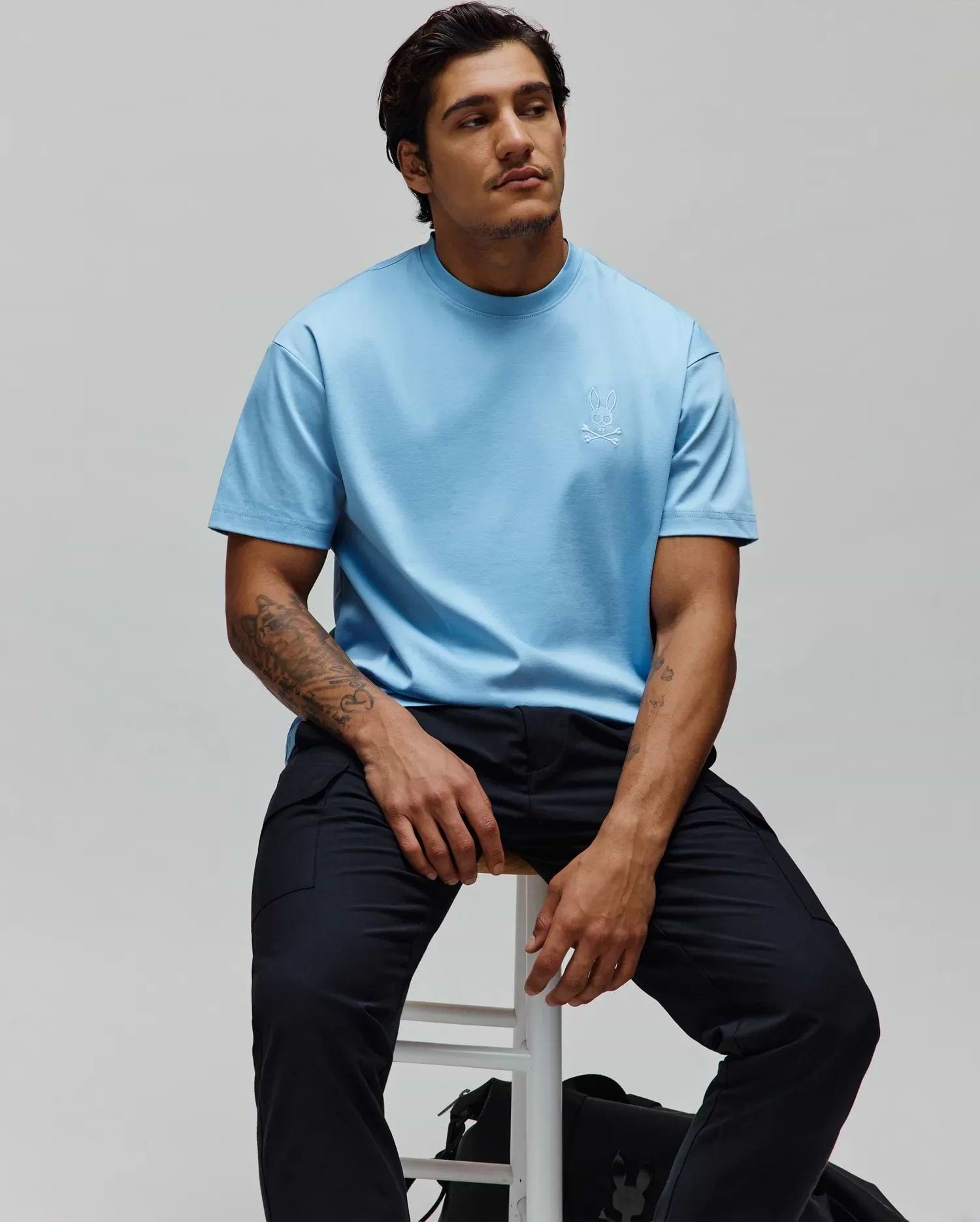Mens Oscar Oversized Tee in light blue jersey knit, featuring a small white embroidered Psycho Bunny skull logo on the left chest, with a relaxed fit.