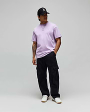 Lavender jersey Mens Oscar Oversized Tee with a white embroidered Psycho Bunny logo on the left chest, black relaxed cargo pants, and a black cap featuring the iconic white-red bunny skull. (3)